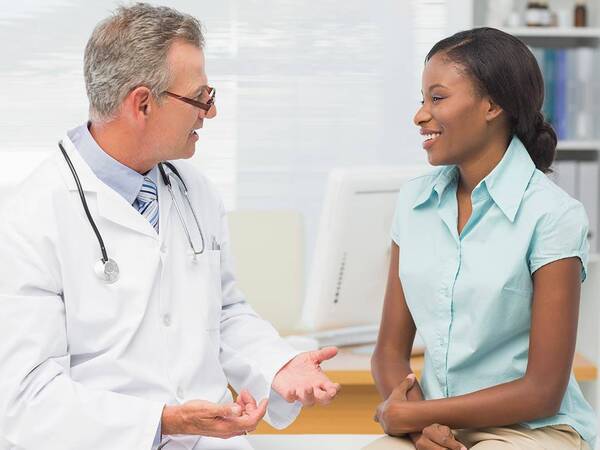 A doctor and patient in a medical office discussing palliative care.