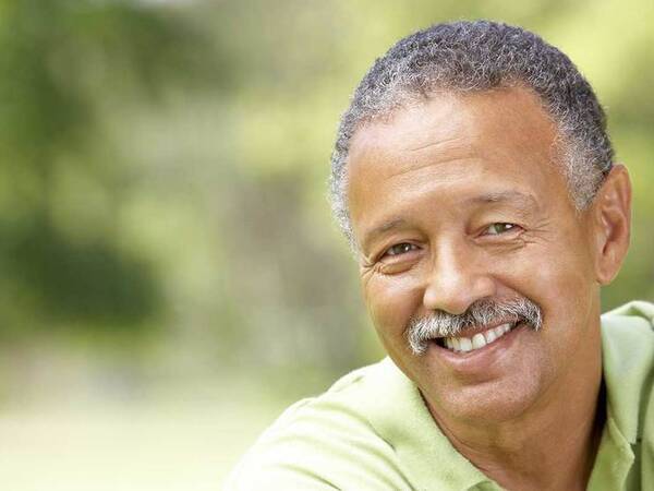 A smiling middle-aged African-American man represents the full life that can be led after soft tissue sarcoma treatment.