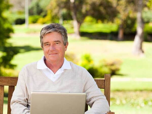 A smiling middle-aged man in a park represents the full life that can be led after retroperitoneal sarcoma treatment.