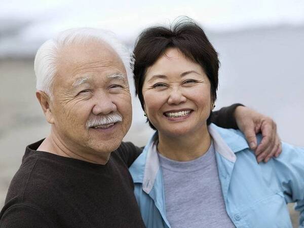 A smiling mature Asian couple represents the full life that can be led after pancreatic neuroendocrine tumor treatment.