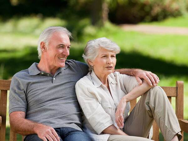 A mature couple on a park bench represent the full life that can be led after pituitary cancer treatment.