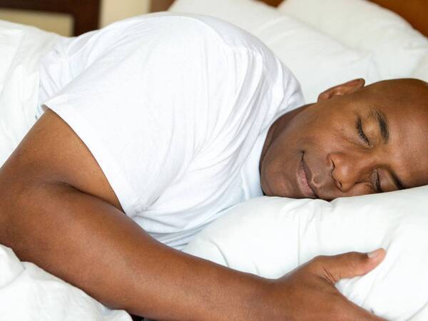 A man sleeping comfortably in bed, representing how you can achieve a good night sleep by receiving sleep medicine treatment from Scripps experts in San Diego.