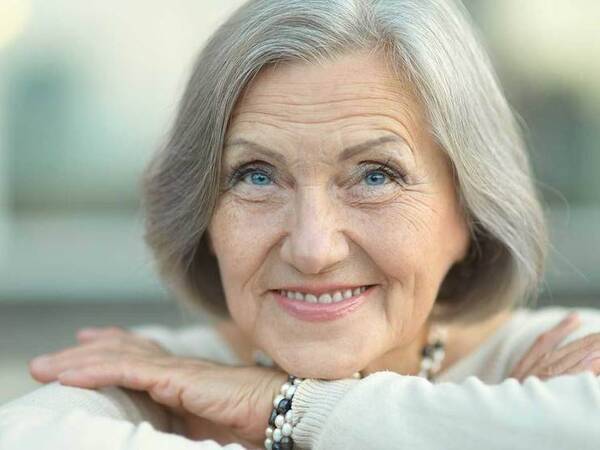 A smiling mature woman represents the full life that can be led after bile duct cancer treatment.﻿