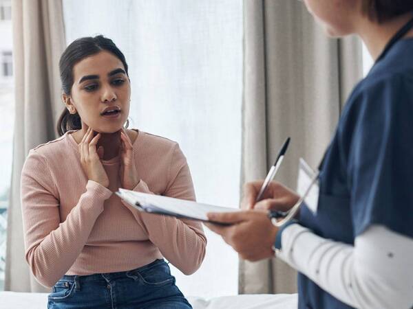 A young woman discussing her concerns with a provider in a clinic, illustrating an appointment at a Scripps HealthExpress location.